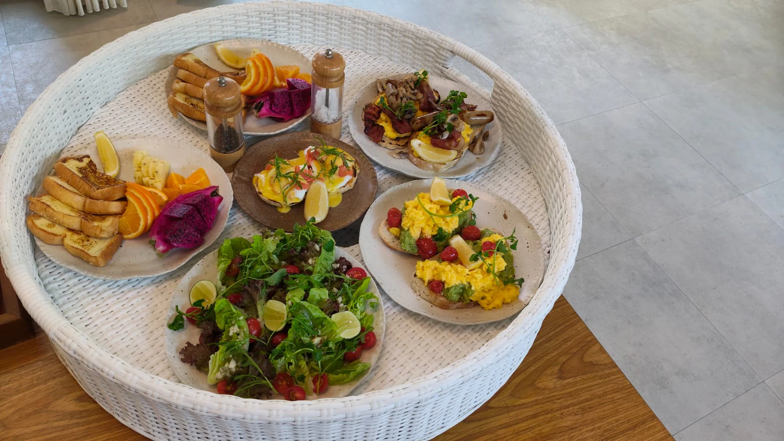 A floating breakfast tray of eggs, toast, fruit and salad on a woven rattan basket