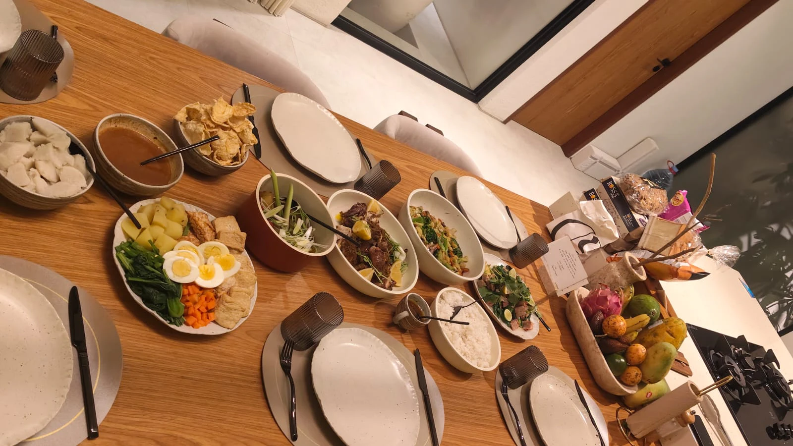 An Indonesian table spread of rice, satay, vegetables and sambal